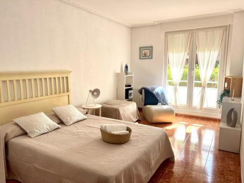 a bedroom with a large bed and a chair at Circobueno de Isla - 5609 in Arnuero
