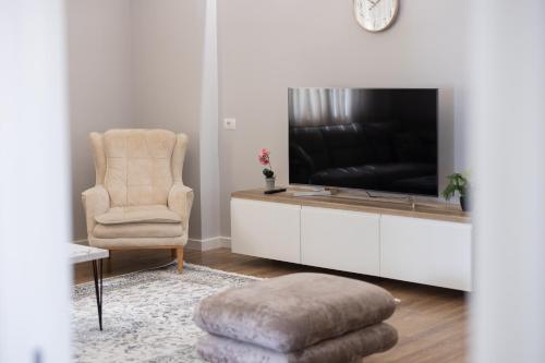 a living room with a television and a chair at Tibi's Villa in Fushë-Krujë