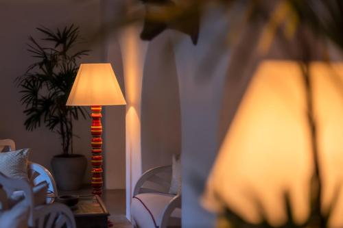a lamp sitting on a table next to a chair at Adigars Manor in Kandy