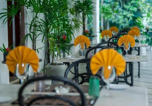 a group of tables and chairs with yellow hats on them at Adigars Manor in Kandy
