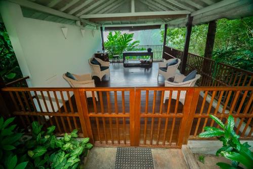 a porch with chairs and a table on a deck at Adigars Manor in Kandy