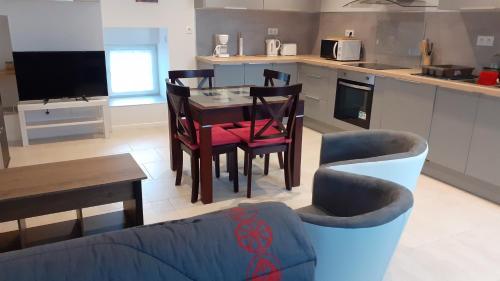 un salon avec une table et des chaises dans une cuisine dans l'établissement Gîtes des Vergers Les Pruniers, à Saint-Pierre-du-Regard