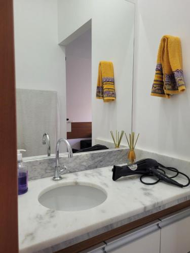 eine Badezimmerablage mit Waschbecken und Spiegel in der Unterkunft Espaço São Rafael Arcanjo in Cachoeira Paulista