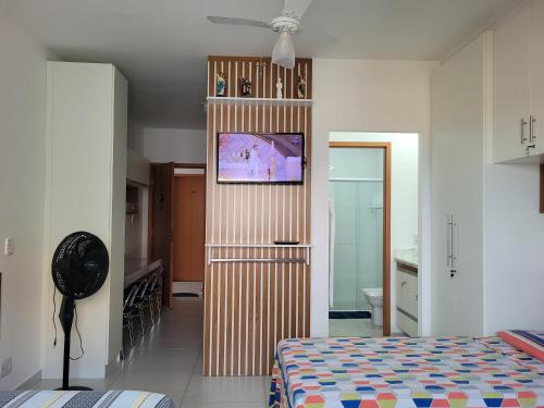 ein Schlafzimmer mit einem Bett und einem Fernseher an der Wand in der Unterkunft Espaço São Rafael Arcanjo in Cachoeira Paulista