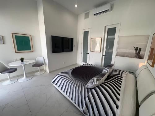 a living room with a zebra print bed and a tv at Men only clothing option guesthouse near Wilton Manors in Fort Lauderdale