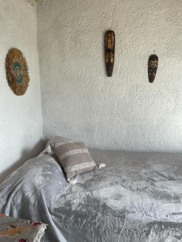 a bedroom with a bed with three skulls on the wall at Alojamiento Sencillo EYO con Baño Privado in Chuy