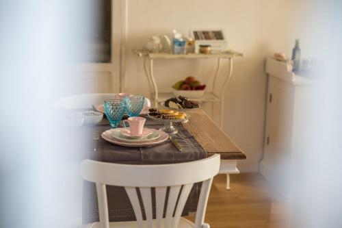 a table with two chairs and a plate of food on it at Palazzo Siena De Facendis in Bitonto