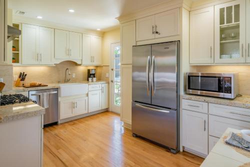 a kitchen with white cabinets and a stainless steel refrigerator at Casa Azul by Paradise Retreats in Santa Barbara