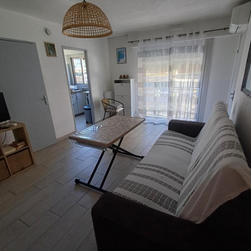 un salon avec un canapé et une table dans l'établissement F1 à 5 minutes des plages et de la gare, à Vallauris