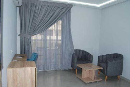 a living room with two chairs and a window at Asswar Al Madina in Fès