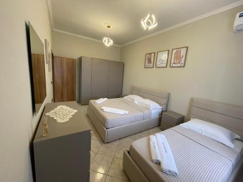ドゥラスにあるRene's Apartmentsの小さなベッドルーム(ベッド2台、テーブル付)