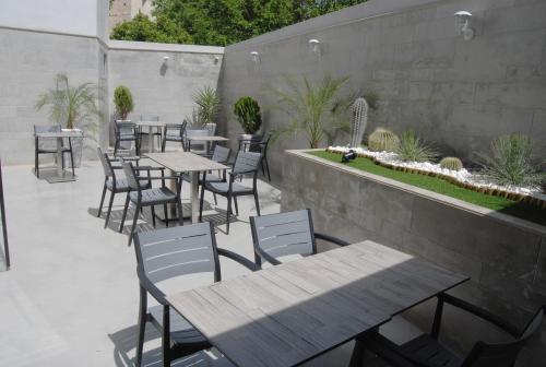 an outdoor patio with tables and chairs and a garden at Asswar Al Madina in Fès