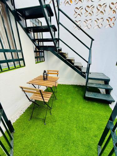 a table and chairs with a staircase and grass at House in the heart of Dos Hermanas in Dos Hermanas