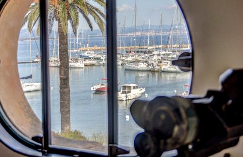 une fenêtre avec vue sur un port de plaisance avec des bateaux dans l'établissement Porquerolles Island architectural seaview, à Hyères