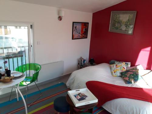 une chambre avec un lit, une table et une fenêtre dans l'établissement Le studio perché, à Carcassonne