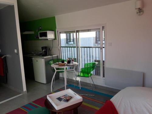 Cette chambre comprend un lit, une table et une cuisine. dans l'établissement Le studio perché, à Carcassonne