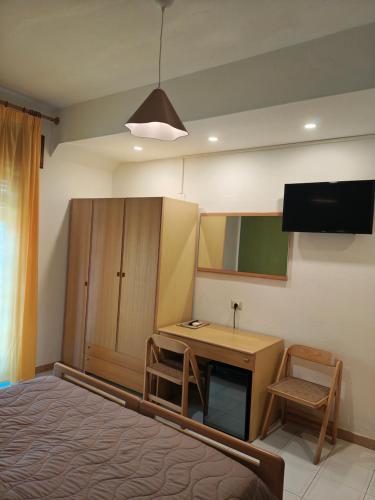 a bedroom with a bed and a desk and a tv at Hotel La Filadelfia in Lipari