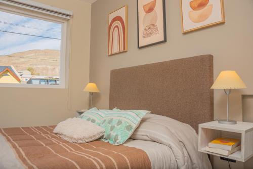 una camera da letto con un letto con una grande finestra di Departamentos Turísticos MD a El Calafate