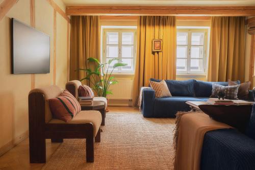 a living room with couches and chairs and a flat screen tv at NELIS I Boutique Apartments in Old Town in Prague