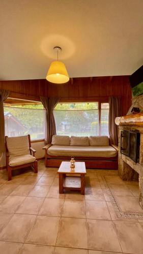 a living room with a couch and a table at Apart Hotel del Pellin in San Martín de los Andes