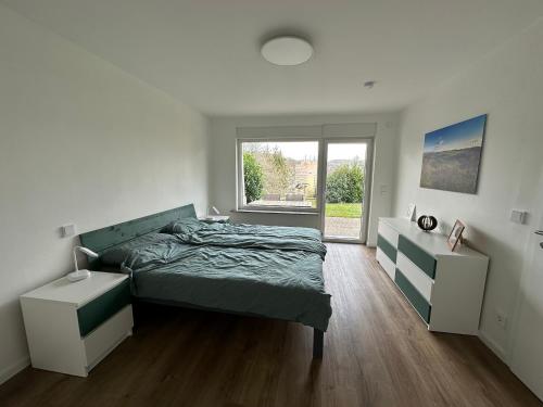 a bedroom with a bed and a large window at Ferienwohnung Schwung in Idar-Oberstein