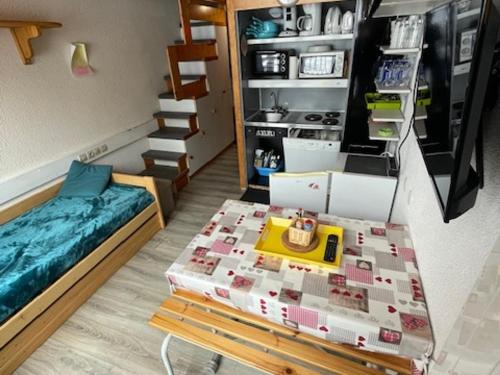 une chambre avec un lit et une table avec des boîtes dans l'établissement Duplex au pied des pistes avec balcon, idéal pour 4/5 personnes - FR-1-346-578, à Arc 1800