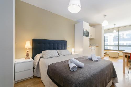 a bedroom with a large bed with a blue headboard at Playa Sanxenxo in Sanxenxo