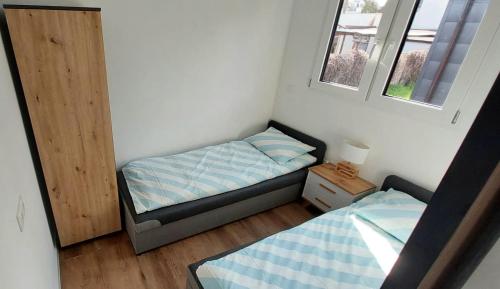 a small bedroom with a bed and a window at Herada Domek 1 in Jastarnia