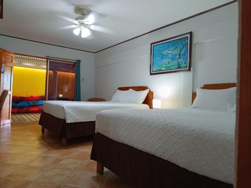 a hotel room with two beds and a window at Banana Bay Marina in Golfito