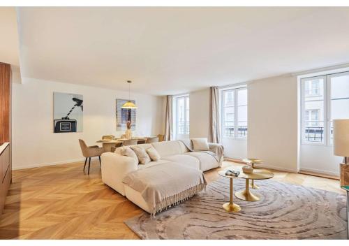 un salon avec un canapé blanc et une table dans l'établissement Sublim AC Apartment Opéra Madeleine, à Paris