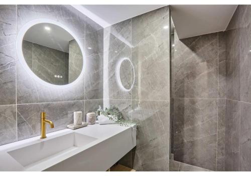 une salle de bain avec un lavabo et un miroir dans l'établissement Sublim AC Apartment Opéra Madeleine, à Paris