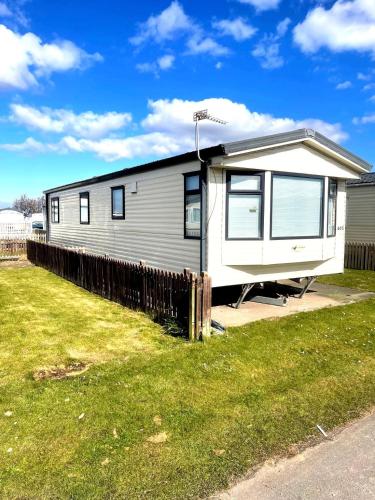 Ein Mobilheim steht in einem Hof. in der Unterkunft Spacious 8-Berth Caravan at Unity Beach Resort in Brean