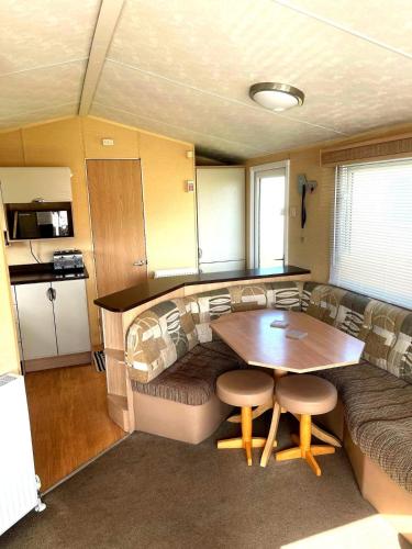 a room with a table and a couch and a kitchen at Spacious 8-Berth Caravan at Unity Beach Resort in Brean