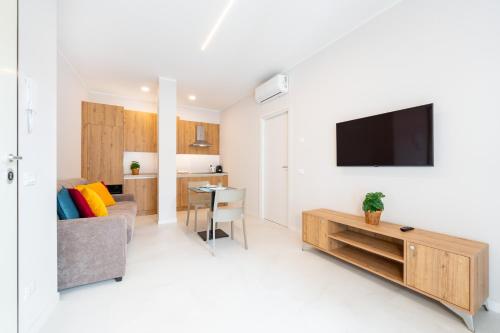 a living room with a couch and a tv on a wall at Borgo Trento Residence in Verona