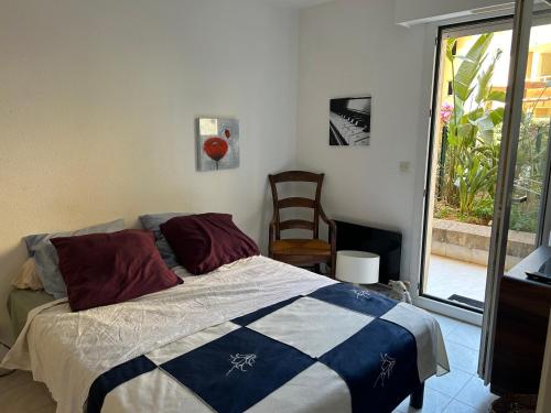 une chambre avec un lit, une chaise et une fenêtre dans l'établissement Escale Port Fréjus vue Esterel, à Fréjus