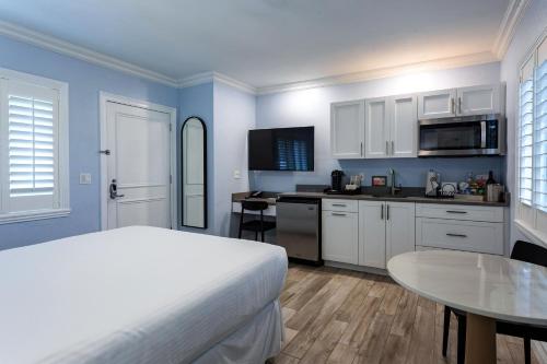 a bedroom with a bed and a kitchen with a table at Crane's Beach House Boutique Hotel & Luxury Villas in Delray Beach