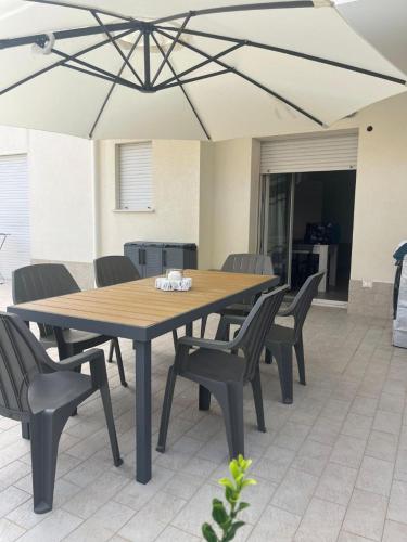 a wooden table and chairs with an umbrella at Sake' Beach in Senigallia
