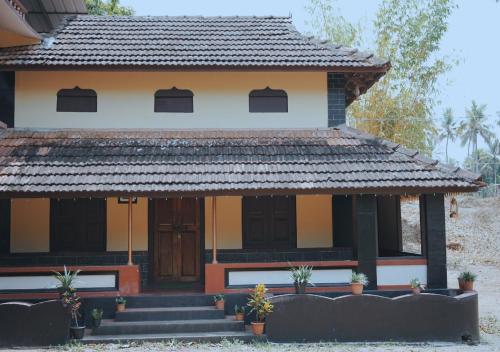 a house with a gate and stairs in front of it at Vintage Vista in Lakkidi