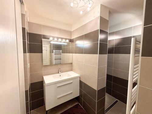 une salle de bain avec un lavabo et un miroir dans l'établissement Azura - Appartement Climatisé 2 Chambres Terrasse Vue Mer avec Parking Privé Gratuit, à Cavalaire-sur-Mer