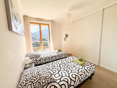 deux lits dans une chambre avec une fenêtre dans l'établissement Azura - Appartement Climatisé 2 Chambres Terrasse Vue Mer avec Parking Privé Gratuit, à Cavalaire-sur-Mer