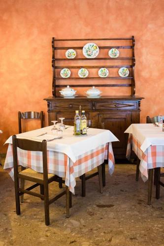 a dining room with two tables and plates on a wall at Albergo Olivo in Belluno Veronese