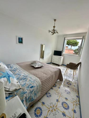 a bedroom with a bed and a chair and a window at Capri Joy Apartments in Capri