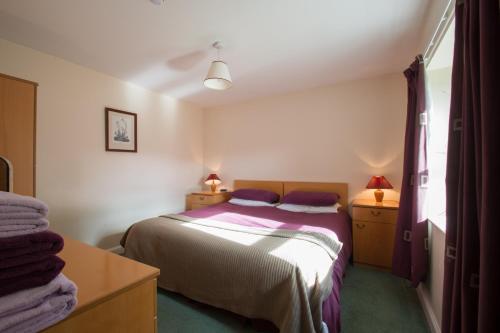 a small bedroom with a bed and two night stands at Blackaddie House Hotel in Sanquhar