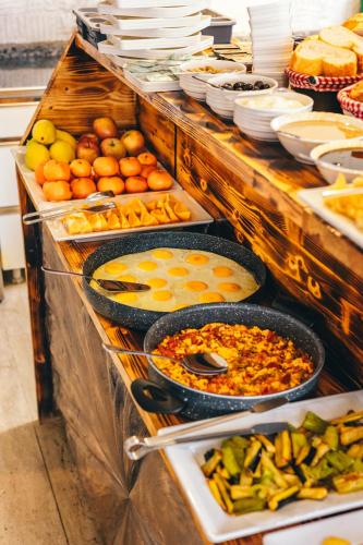 Un buffet con muchos tipos diferentes de comida en sartenes. en Cappadocia Divin House, en Göreme