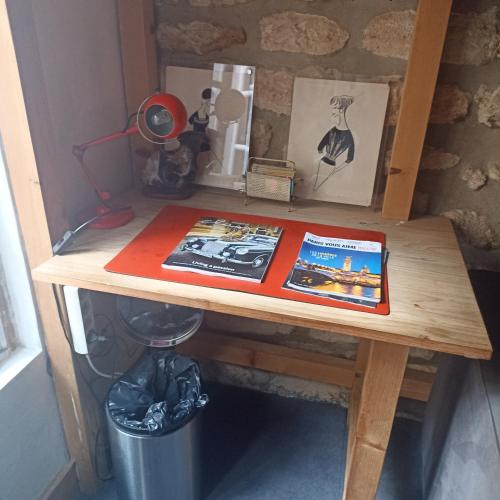 une table en bois avec deux brochures en haut dans l'établissement charmant studio à Marais Paris centre, à Paris