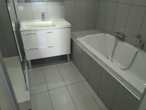 une salle de bain blanche avec un lavabo et une baignoire dans l'établissement Appt F3 Banyuls sur mer, à Banyuls-sur-Mer