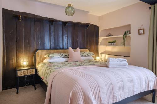 a bedroom with a bed with pink pillows at Wordsworth Lodge in Ambleside