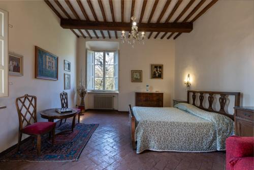 a bedroom with a bed and a table and a chair at Il Casale Di Villa Rossi in Lucca
