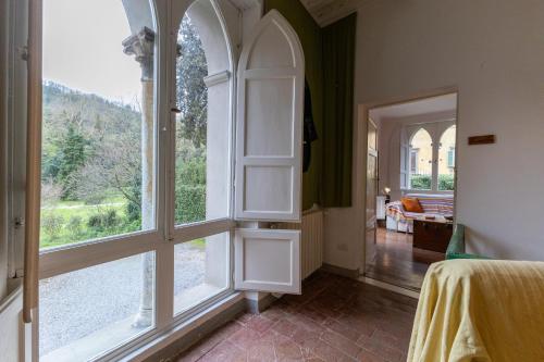 a bedroom with a large window and a room with a bed at Il Casale Di Villa Rossi in Lucca