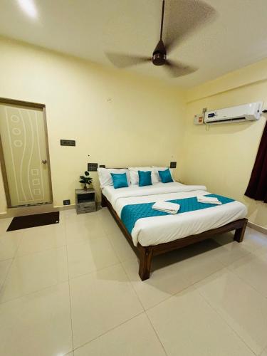 a bedroom with a bed with blue pillows and a ceiling at Royal Dreams Beach View in Puducherry